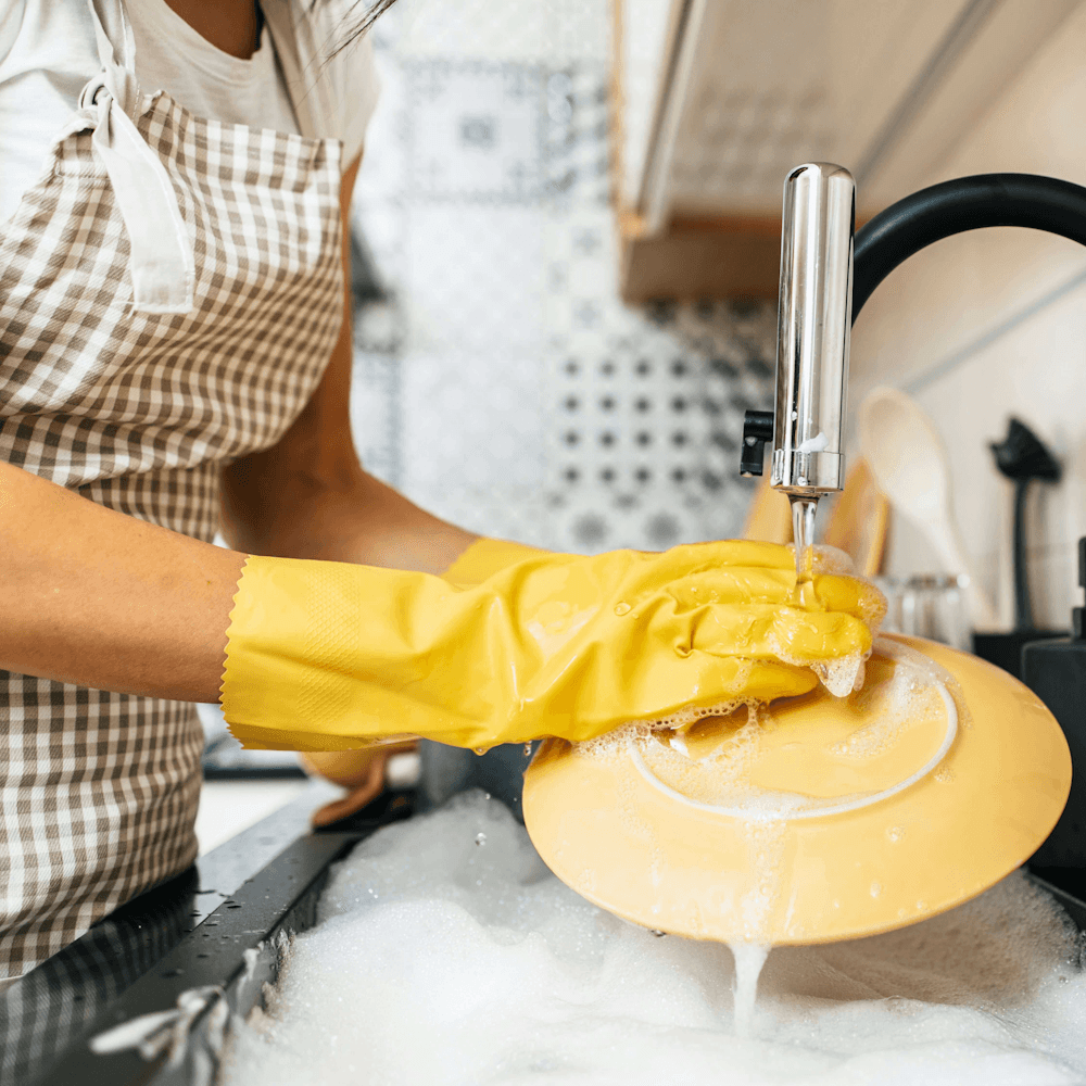 Illustration of a person washing a plate with soap